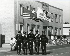 Primary view of object titled '[APD Color Guard marching in the Arlington Fourth of July Parade, late 1980s]'.