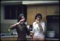 Photograph: [Two Women Stand in a Kitchen at a Library Party]