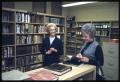 Photograph: [Two Women Speak in the Literature Section of a Library]