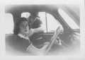 Photograph: [Jean Bryan in a car with Ed Frazier reaching in through the window]