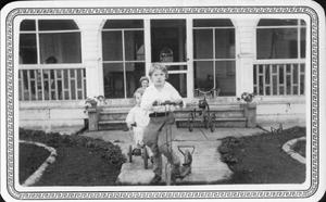 Primary view of object titled '[Children on scooters and bicycles at Mary Dee and August Myers' home]'.