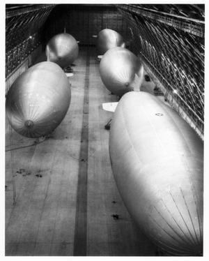 Primary view of object titled '[Hangar at Hitchcock Naval Air Station with five K-type blimps]'.