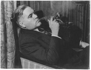Primary view of object titled '[George A. Hill, Jr. leaning back in armchair, cigar in hand]'.