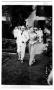Photograph: [Mary Van den Berge Hill walking with unidentified man in white suit]