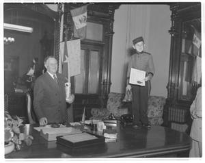 Primary view of object titled '[The "Phillip Morris Midget" standing on a desk next to Governor Jester]'.
