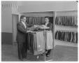 Primary view of [Jack and Morton Plotsky standing next to pants rack in clothing store]