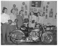 Primary view of [Men standing around Harley-Davidson motorcycle]