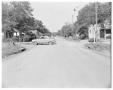 Photograph: [A car parked in the middle of the intersection of Navasota and Holly]
