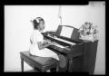 Photograph: [Photograph of a Young Girl Playing a Piano]