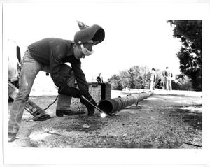 Primary view of object titled '[Photograph of Jerry Foote Welding at Flag Pole Hill]'.