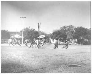 Primary view of object titled '[Photograph of Teen Boys Playing Football in a Park]'.