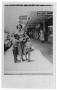 Photograph: [Woman and children in front of stores]