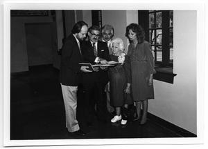 Primary view of object titled '[Group looking at document with Tom Kreneck]'.