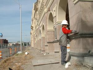 Primary view of object titled '[Workman smooths cement on the front of the new Fort Worth Mercado building]'.