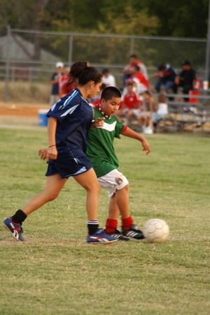 Primary view of object titled '[Boy and girl playing soccer]'.