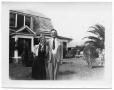 Photograph: [Young Woman and Man in Front of House]