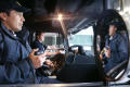 Primary view of [Two firemen sit in the front seat of a fire engine]