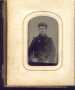 Photograph: [Unidentified young man wearing dark clothing and a hat]