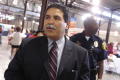 Photograph: [Michael Hinojosa with police officer in background]