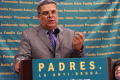 Photograph: [Carlos Ugarte speaking at a podium]