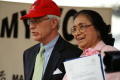 Photograph: [Adelfa Callejo standing next to man with red cap]