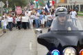 Photograph: [Marching protesters behind police officer on motorcycle]
