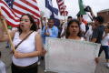Photograph: [Protesters holding flags and handwritten sign]
