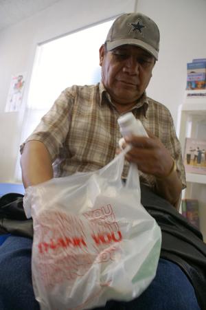 Primary view of object titled '[Man with plastic grocery bag and medicine]'.