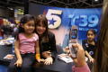 Photograph: [Photo of Gabriela and young fan being taken with a cellphone]