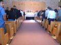 Photograph: [Mourners standing in rows of pews]