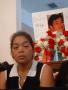 Photograph: [Woman crying with photo of Edgar Vera and flowers in background]