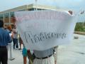 Primary view of [Man holding large white paper sign]