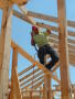 Photograph: [Man climbing on wood frame]