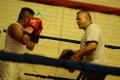 Primary view of [Young man with hands raised practicing with boxing instructor]