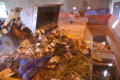 Photograph: [Excavator moving pile of debris]