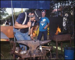 Primary view of object titled '[Basil Garcia Hammering Hot Metal Over an Anvil]'.