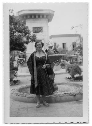 Primary view of object titled '[Marie Burkhalter standing in front of a fountain]'.