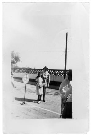 Primary view of object titled 'Man and a young girl standing in street'.