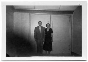 Primary view of object titled 'A man and woman standing in front of a pair of double doors'.