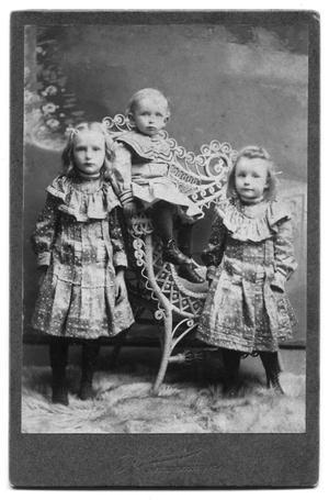 Primary view of object titled 'E.H. Scrvner's three children in elegant clothes in a studio portrait'.