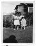 Thumbnail image of item number 1 in: 'Two children standing next to a fence in the backyard of a house'.