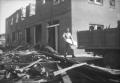 Photograph: [Photograph of Man Cleaning Debris After Tornado]