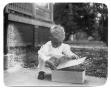 Photograph: [Child playing with a box]