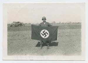 Primary view of object titled '[Donald Coombes Holding a Nazi Flag]'.