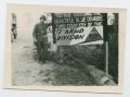 Photograph: [Soldier Standing by Sign]