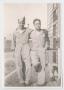 Photograph: [Two Soldiers Posing Near Barracks]