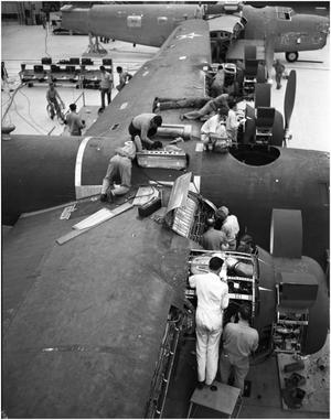 Primary view of object titled '[Men Working on an Airplane Wing]'.