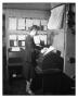Photograph: [Merle Berrett Filing Messages Received on the Teletype]