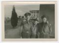 Photograph: [Three Uniformed Men Standing by a Wall]