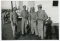 Photograph: [Four Soldiers Standing by a Building]